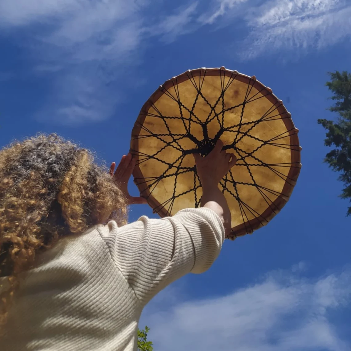 Reverso de un tambor con tejido de cuerdas frente al cielo